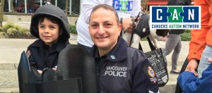 Canucks Autism Network logo on a photographic policeman with child background